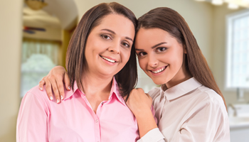 A mother and daughter smiling within a patient room.