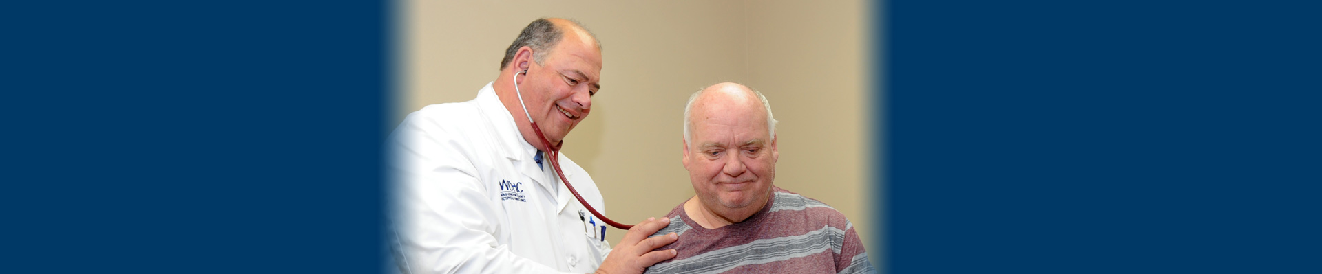 Banner picture of a male Physician checking an older male patient's breathing with a stethoscope.