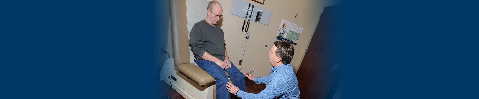 Banner picture of a male Physician sitting on a stool in front of an elderly  male patient. The elderly patient is looking at the Physician.
