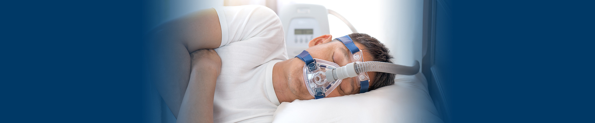 Banner picture of a male patient lying on his side wearing a CPAC. He is sleeping and having a  
Sleep Study Test.