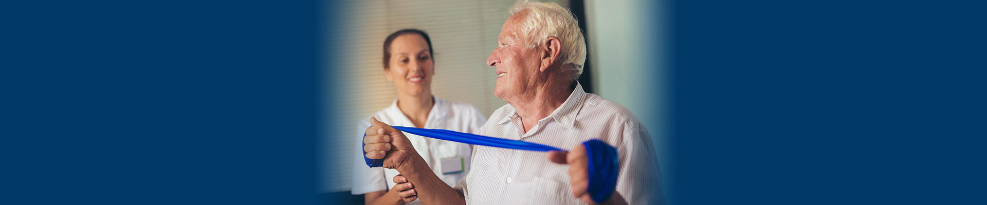 Banner picture of a male patient doing Occupational Therapy. There is a female Occupational Therapist behind him as he is holding a stretchy material with both hands pulling it apart.