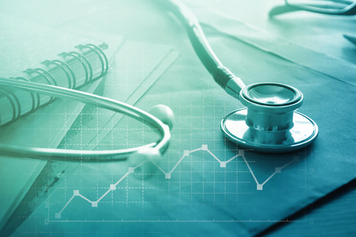 Banner picture of a notebook,  papers, and a stethoscope sitting on top a Doctor's desk . Click here to find a provider or doctor or physician. An image of a stethoscope placed on a papers