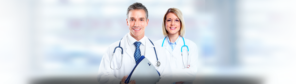 Banner picture of a female and male Physician, smiling. They are both wearing medical coats and stethoscopes around their neck and he is holding a clipboard up against his body.