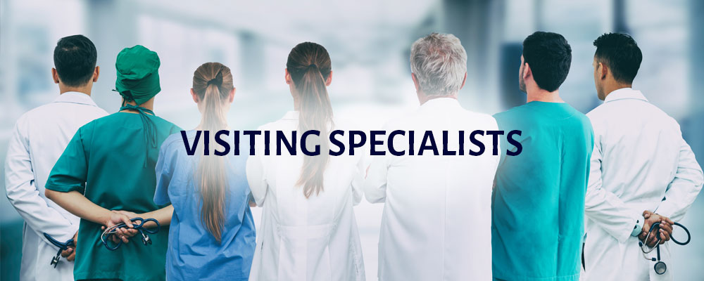 Banner picture of seven health professionals dressed in a variety of medical attire, scrubs, surgical gowns, and lab coats (back view) . Banner says:
VISITING SPECIALISTS