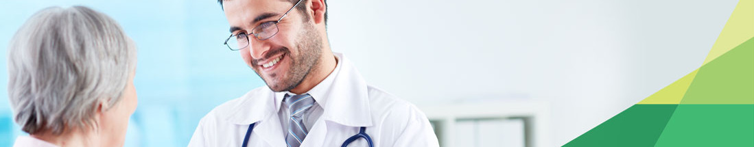 Banner picture of a male Physician smiling at an elderly female patient.