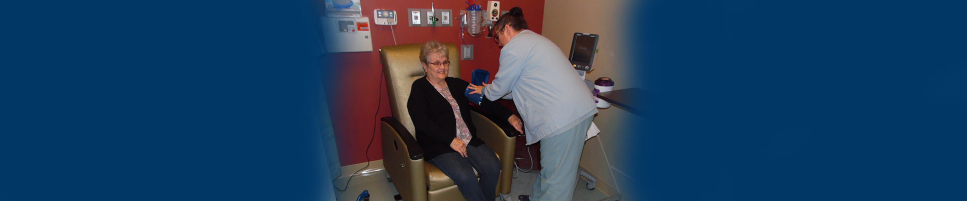 Banner picture of a female Nurse putting a blood pressure cuff around a female elderly patients arm to check her blood pressure for Ambulatory Care.