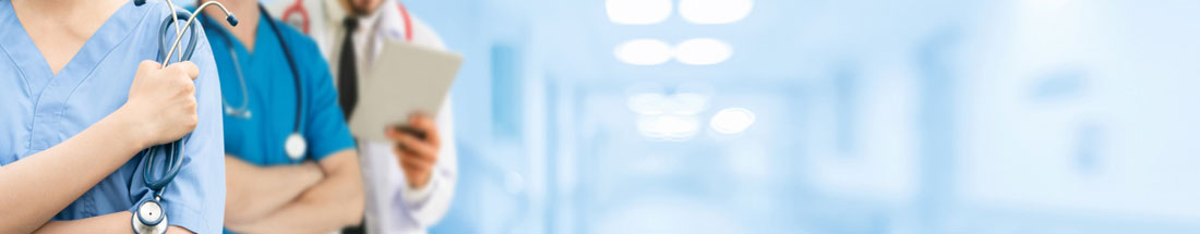 Banner picture of two nurses standing in a hallway with a doctor.