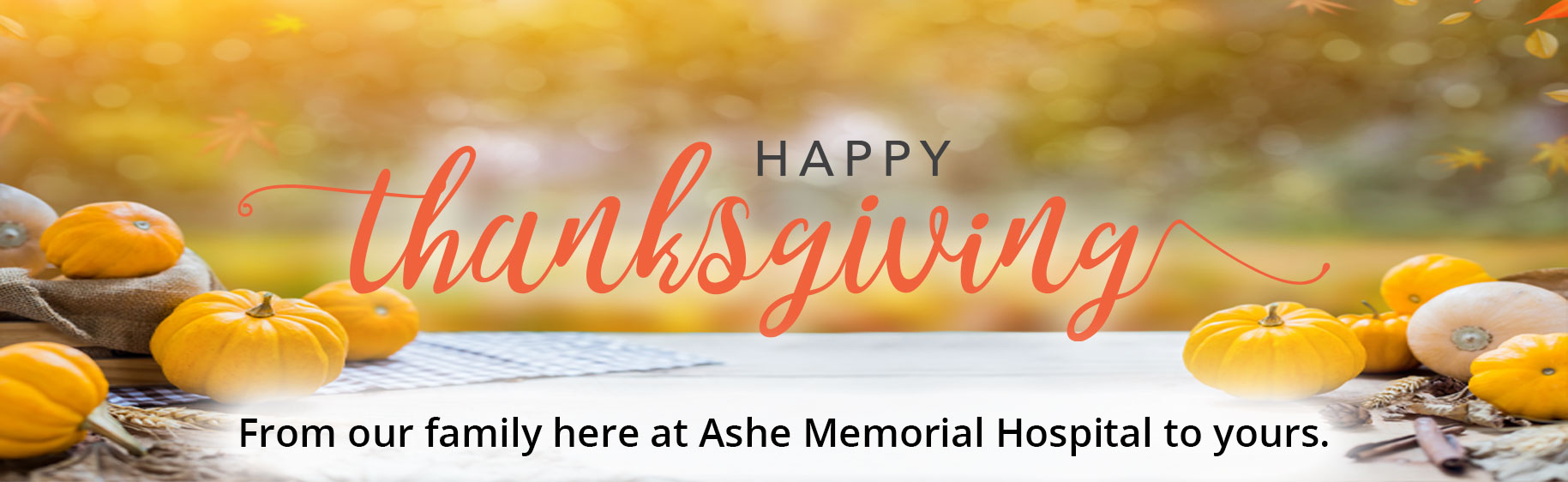 Thanksgiving themed banner with pumpkins on a table with a faded background 

Banner says:
HAPPY Thanksgiving
From our family here at Ashe Memorial Hospital to yours