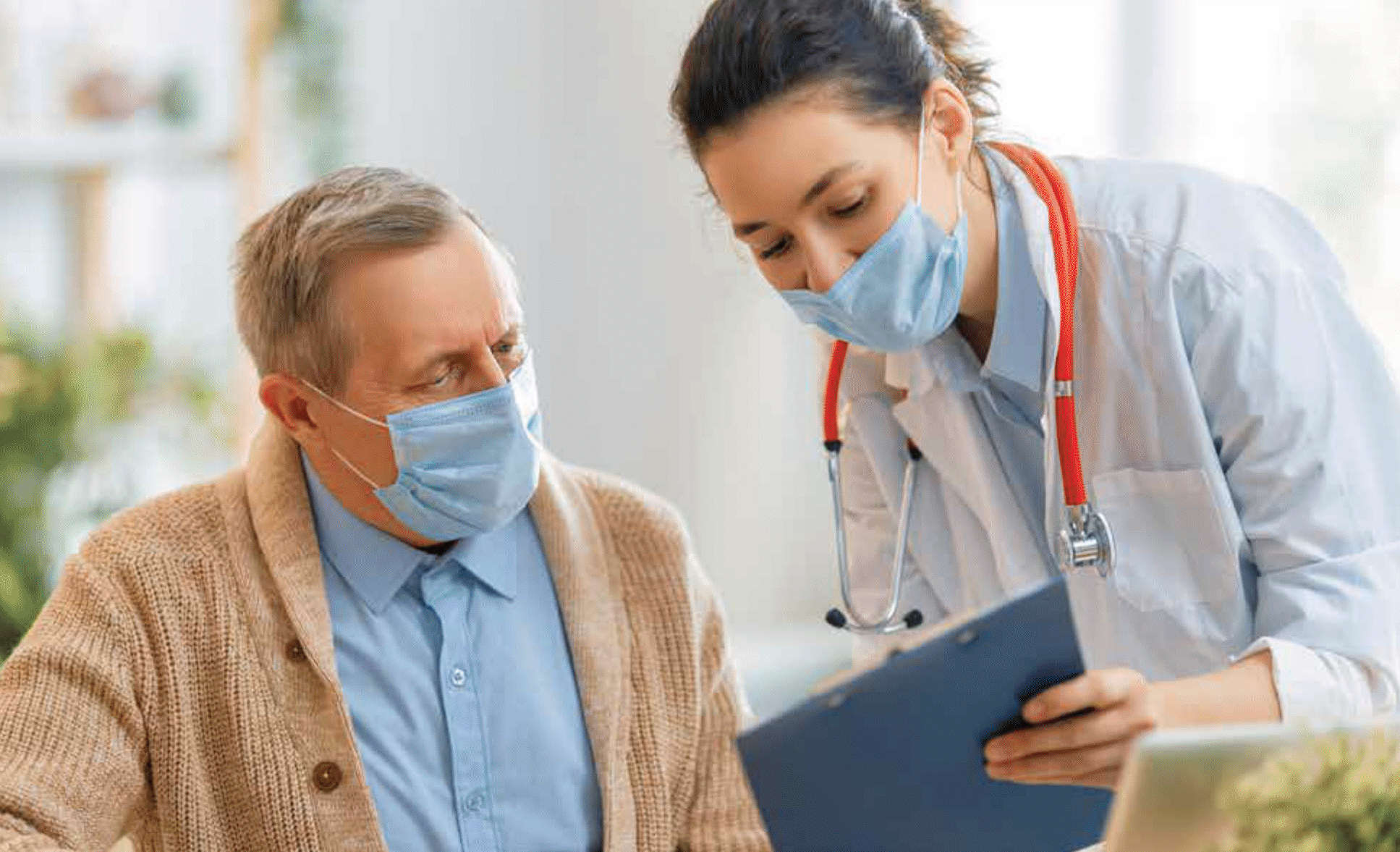 A mask-wearing knowledgeable nurse practitioner shows a clipboard to a mask-wearing, beige jacket over a blue dress-shirt patient