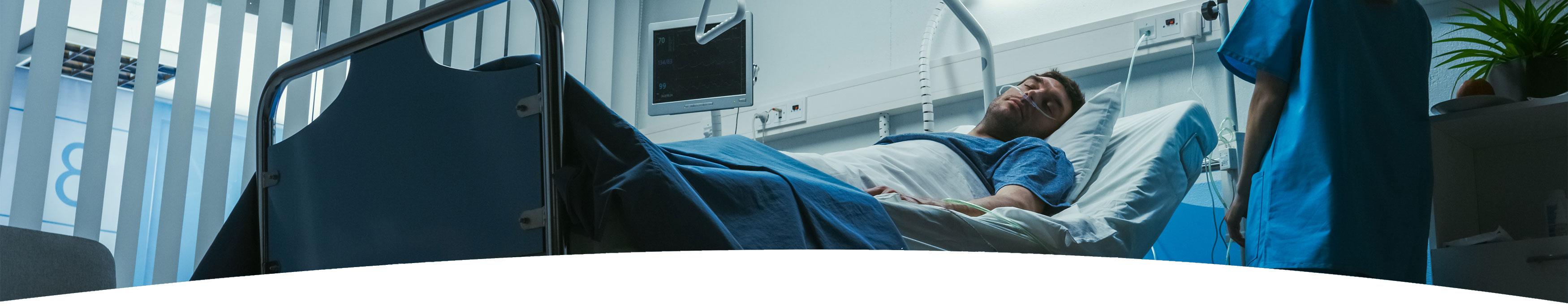 Banner picture of a male patient sleeping in a swing bed with a nasal cannula in his nose. There is a female Nurse standing next to his side, checking on him.