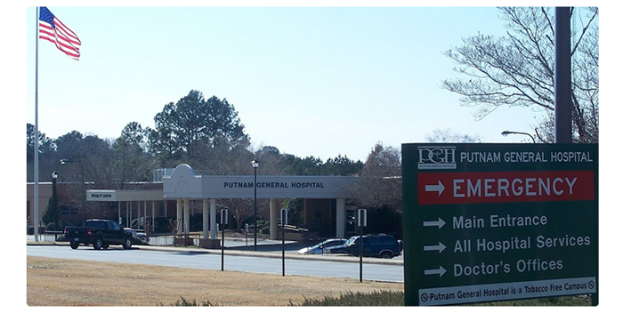 Banner picture of an outside shot of Putnam General Hospital. There is a hospital sign, American flag, and front parking.