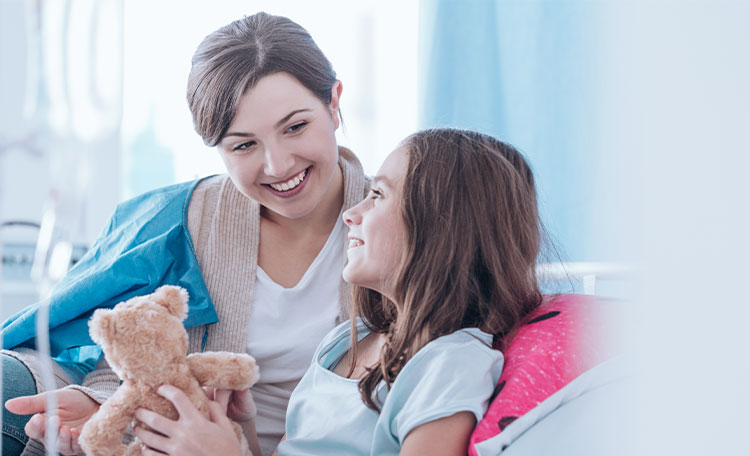 Banner picture of a mother smiling at her daughter who is sitting up in a swing bed holding a teddy bear.