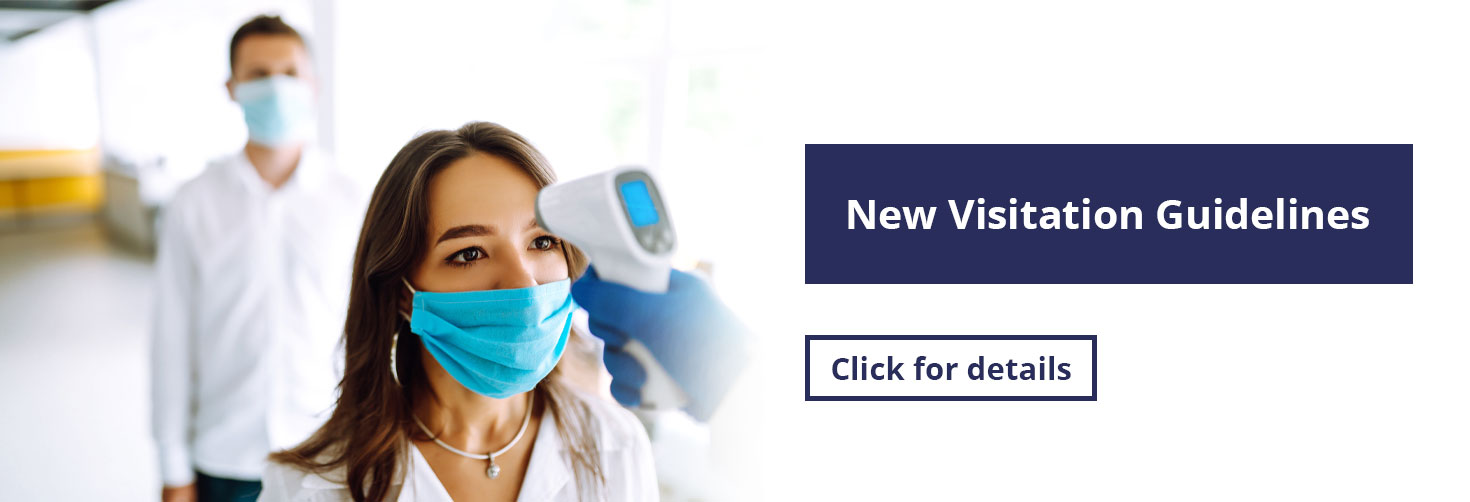 Banner picture of a female wearing a mask and having her temperature taken by a Medical Professional who is wearing gloves. There is a male behind her wearing a mask in line to have his temperature taken too. Banner says:

Effective 3/7/22:

New Visitation Guidelines