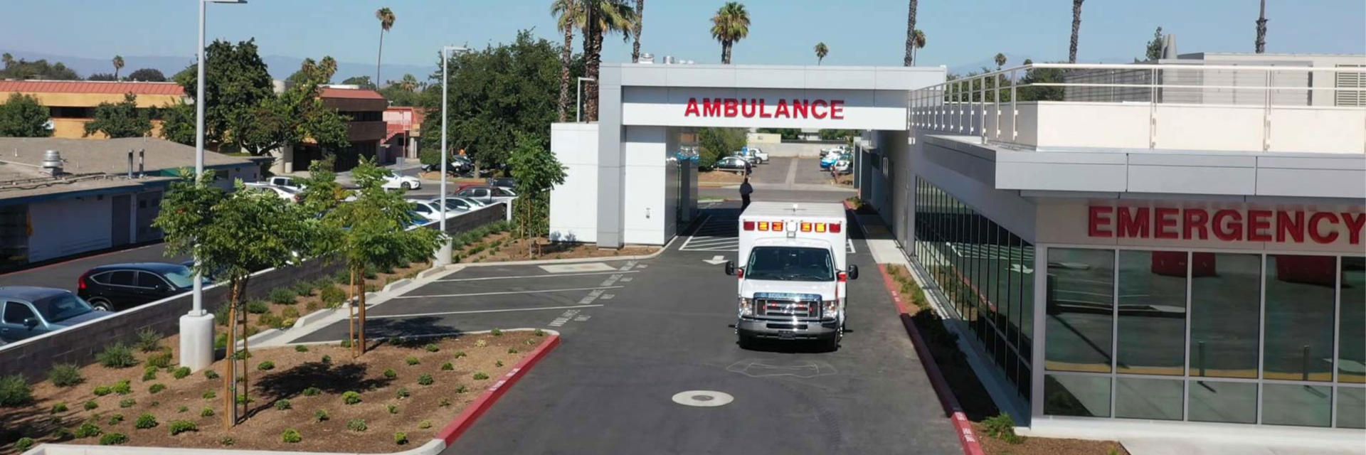 EMERGENCY entrance showing the side of hospital of an ambulance and overhead that says: AMBULANCE.