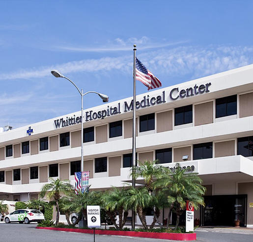 Whittier Hospital Medical Center Building With Sign and Palm Trees with Flag Poles