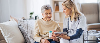 Home Health- Nurse and Elderly patient sitting down and smiling,