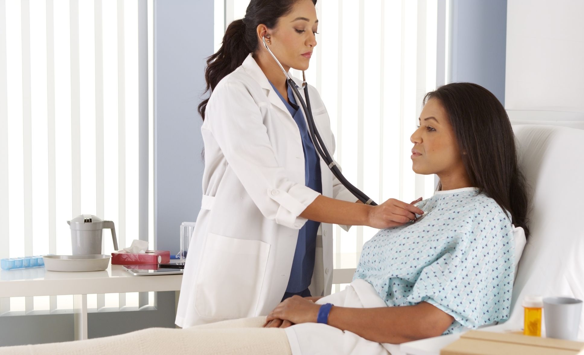 female provider listening to heart beat of patient