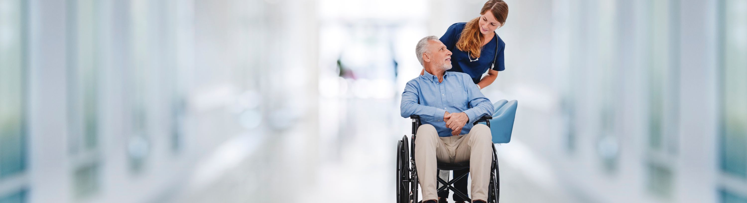 woman pushing a man in wheelchair
