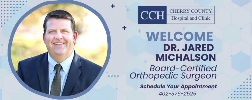 CHERRY COUNTY HOSPITAL WELCOMES DR. JARED MICHALSON, BOARD-CERTIFIED ORTHOPEDIC SURGEON. SCHEDULE YOUR APPOINTMENT 402-376-2525. LIGHT BLUE SHADE BACKGROUND WITH DR. MICHALSON WEARING A NAVY SUIT JACKET AND TIE, SMILING IN AN OUTDOOR PROFESSIONAL PHOTO.